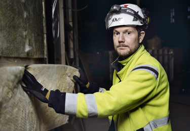 En person i varseljacka och hjälm.