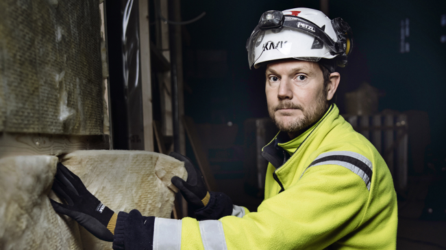 Person i varseljacka och hjälm.