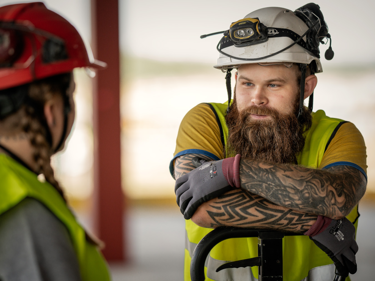 Två byggnadsarbetare samtalar med varandra