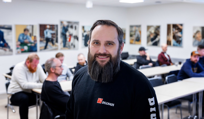 Handledare som tittar in i kameran med oskarpa människor i bakgrunden