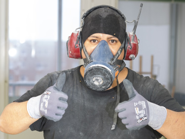 Byggnadsarbetare som arbetar med rivning gör dubbel tumme upp