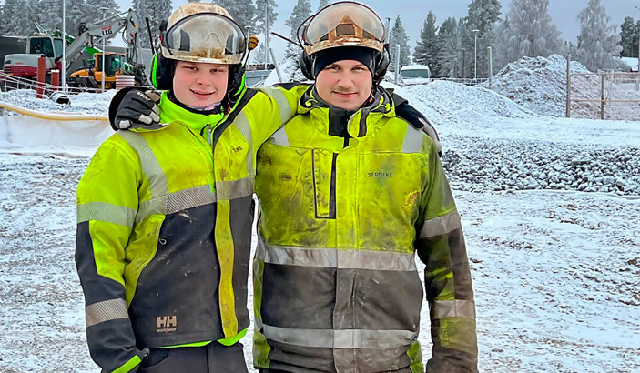 Två personer i varseljackor och hjälmar.