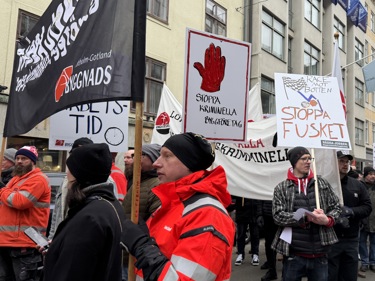 Byggnadsarbetare med plakat i en manifestation