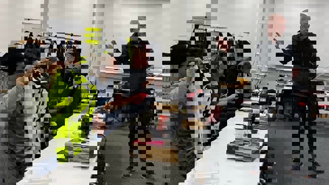 Man som pratar medan kläder skickas runt.