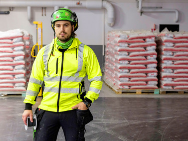 Person i varseljacka och hjälm.